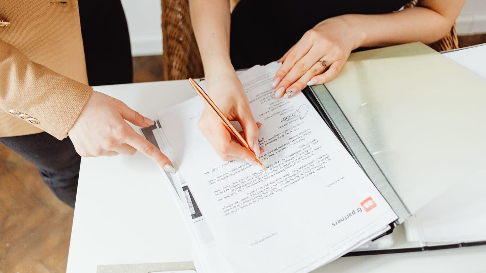 Client and agency lead signing an approval document at a desk, marking a project milestone